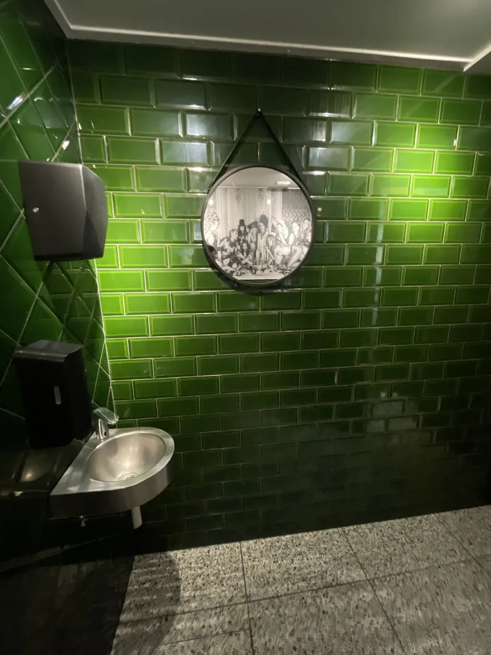 Round mirror and green tiling